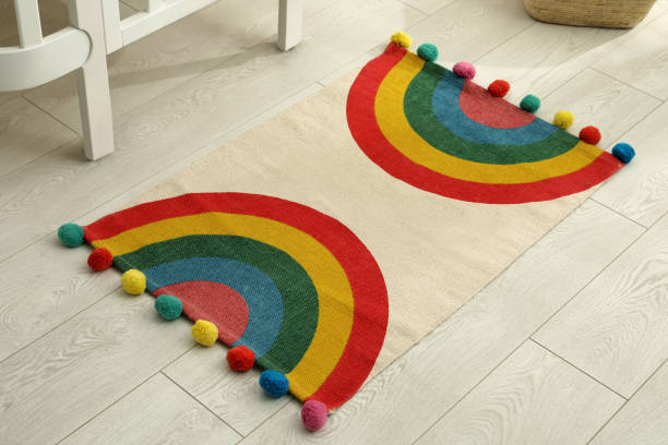istock Stylish rug with rainbow on floor indoors 1326064507