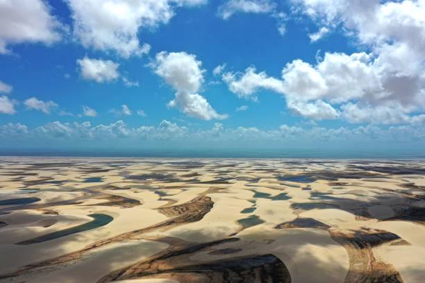 Lençóis Maranhenses, Maranhão, Brazil. Aerial landscape of tropical scenery vacations on destination in Brazil. Lençois Maranhenses National Park, Maranhao, Brazil. Sandy dunes and rain water lagoons landscape. Brazil Northeast landmark. lençóis maranhenses, maranhão, brasil. paisaje aéreo de vacaciones de paisajes tropicales en destino en brasil. parque nacional lençois maranhenses, maranhao, brasil. paisaje de dunas arenosas y lagunas de agua de lluvia. hito del noreste de brasil.
