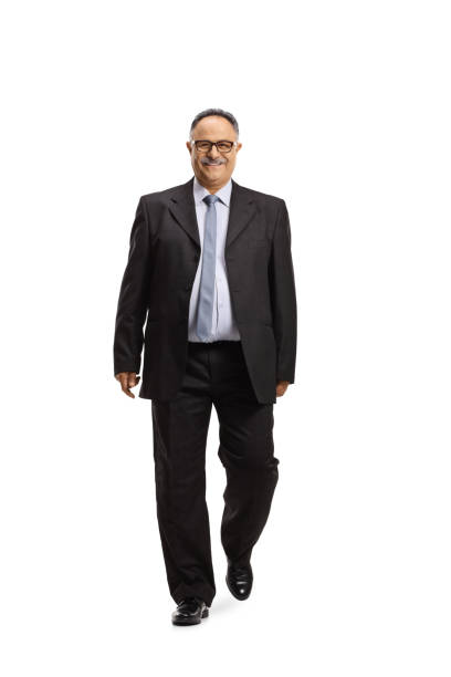 Full length portrait of a mature businessman smiling and walking towards camera Full length portrait of a mature businessman smiling and walking towards camera isolated on white background chubby arab stock pictures, royalty-free photos & images