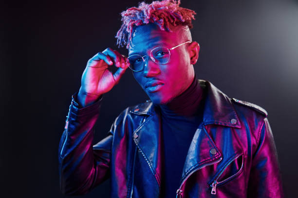 istock Futuristic neon lighting. Young african american man in glasses standing in studio 1326066260