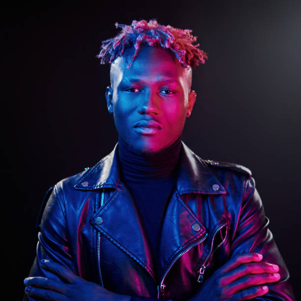 istock Futuristic neon lighting. Young african american man standing in studio with arms crossed 1326066310