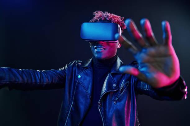 istock Virtual reality experience. Futuristic neon lighting. Young african american man in the studio 1326067423