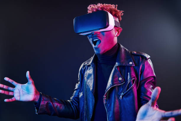 istock Virtual reality experience. Futuristic neon lighting. Young african american man in the studio 1326067554