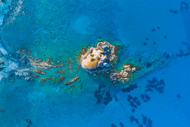 istock Island and Shallow water in Blue Ocean. Sharp cliff from stone. Rocky reef with turquoise water, Sea waves on beautiful beach aerial view drone shot, Tourism destination, Cyprus 1326068715