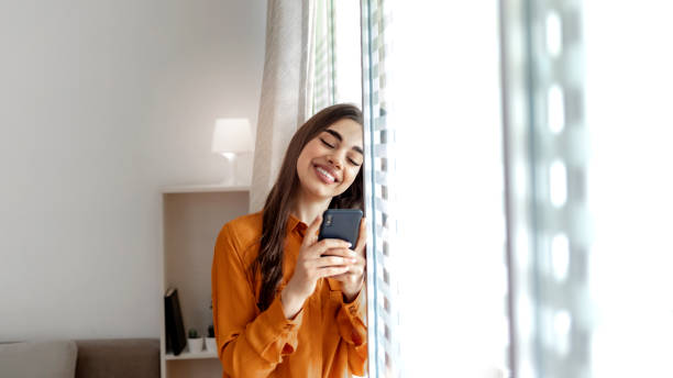 istock Smiling business woman using phone in office. 1326069613