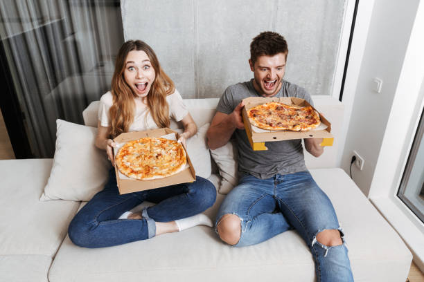 istock Happy young couple holding boxes with pizza 1326070007