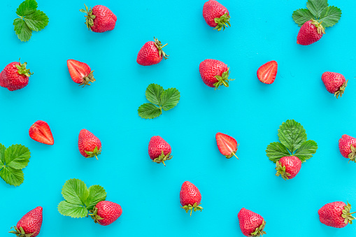 Group of ripe strawberries with green leaves.