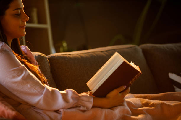istock Young woman relaxing in the evening and reading a book 1326071278