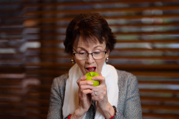istock Senior woman about to eat an apple. 1326071362