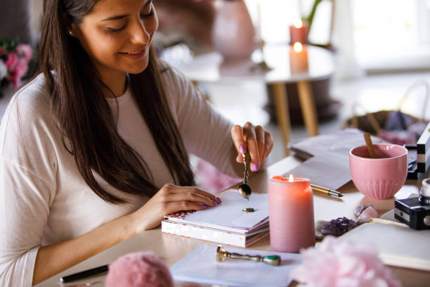 istock Young woman pouring melted sealing wax on an envelope 1326071408