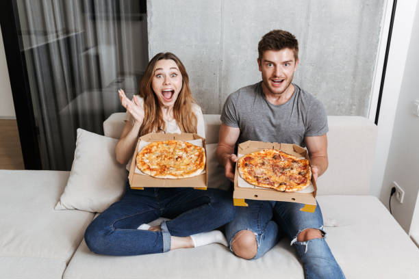 istock Cheerful young couple holding boxes with pizza 1326071581