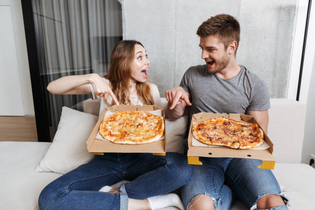 istock Cheerful young couple holding boxes with pizza 1326071599