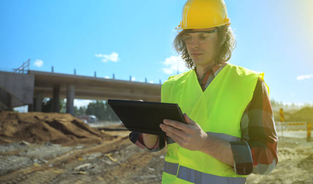istock Builder with documents on the background of a road junction construction site. 1326076332