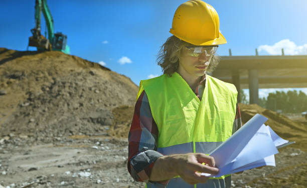 istock Builder with documents on the background of a road junction construction site. 1326076333