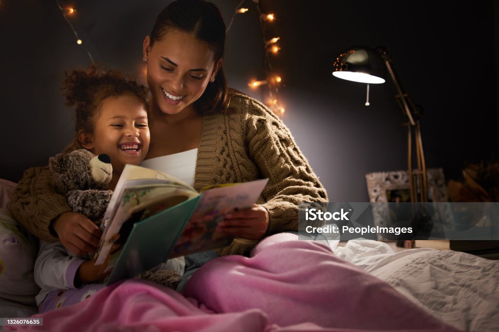 Shot of a young mother reading her daughter a bedtime story And then the princess was rescued Child Stock Photo