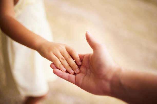 colpo di un genitore che tiene mano ai figli - holding hands human hand child mother foto e immagini stock