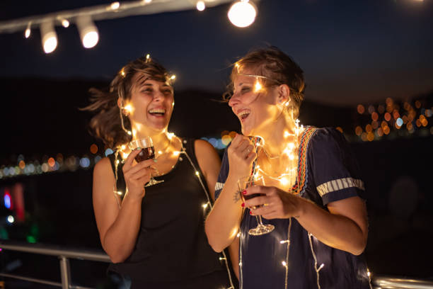 istock Two friends enjoying night out at rooftop party 1326077296