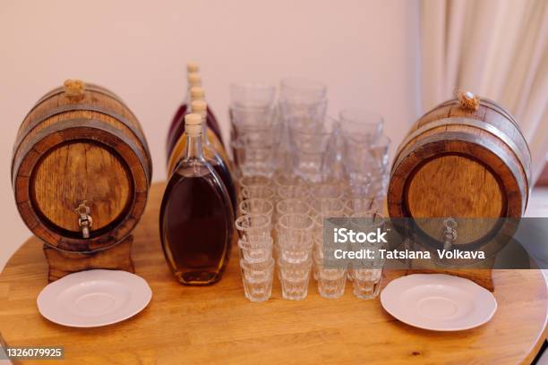 Two Barrels Of Local Traditional Alcoholic Beverages And Several Glass Glasses Are Prepared For Tasting On Round Wooden Table Recreation And Travel Festive Events National Cuisine And Drinks Stock Photo - Download Image Now