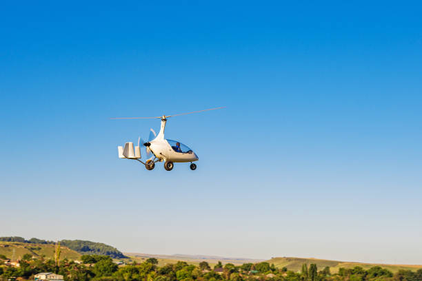 Autogyro Calidus taking off over an unpaved airfield