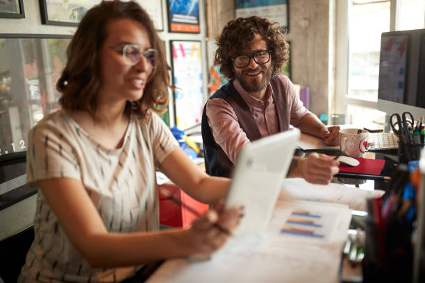 istock Young colleagues are watching tablet content while working in the office together. Employees, office, work 1326082130