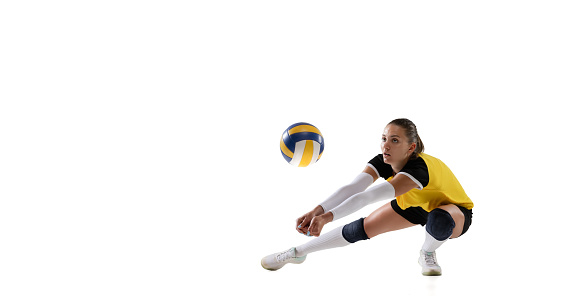 Game in defense. Female professional fit volleyball player with ball isolated on white studio background. The athlete, exercise, action, sport, training, fitness concept. The girl in motion.