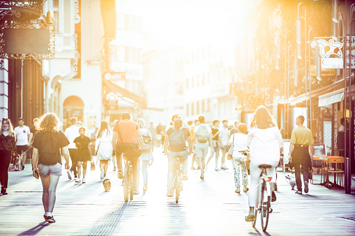 Blurred crowd of people on Copova pedestrian street in Ljubljana at sunset. Urban lifestyle and mobility concept