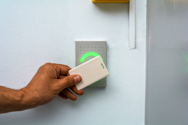 istock Close-up of a hand using a white keycard to open an electronic door lock with an access control system. 1326082415