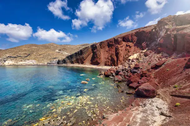 The impressive red beach with volcanic rock formations and turquoise sea on the island of Santorini, Greece, during summer time