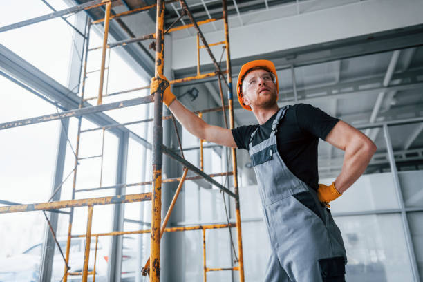 istock Man in grey uniform works with construction indoors in modern big office at daytime 1326084029