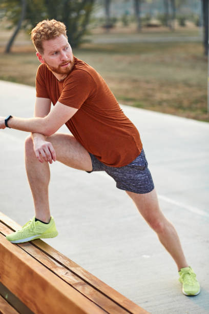 istock Sporty man stretching on a park bench. 1326085600