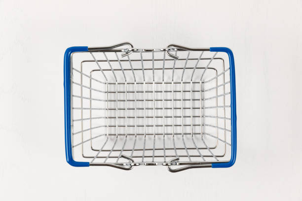 istock empty metal shiny basket with grocery handles on white wooden table background 1326086745