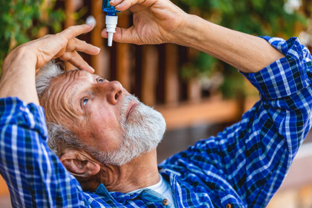 elderly person using eye drops - dry aged imagens e fotografias de stock