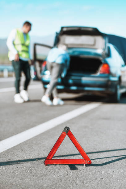 casal configura triângulo de emergência após falha do carro na rodovia - acidente evento relacionado com o transporte - fotografias e filmes do acervo