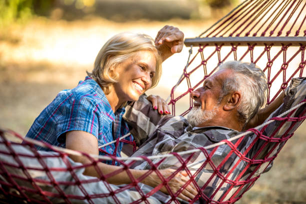 istock Senior couple resting in comfortable hammock at green garden 1326087540
