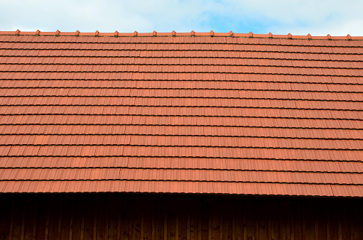 view of the roof made of red brick burnt tiles of the beaver type used in Central Europe on all historical roofs, especially in Austria. the bags overlap several times, they look like beaver teeth, type