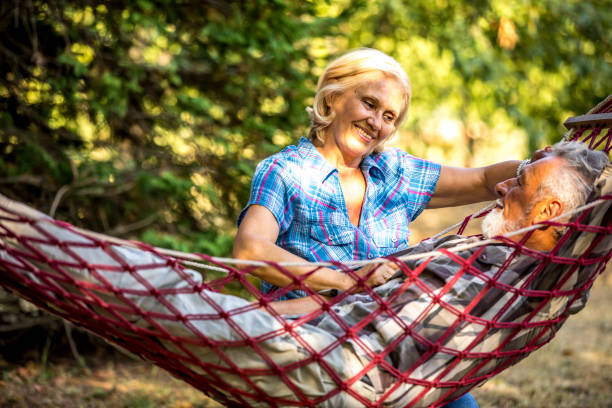 istock Senior couple resting in comfortable hammock at green garden 1326088490