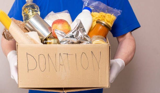 istock A man holding a donation box of different products background 1326089466
