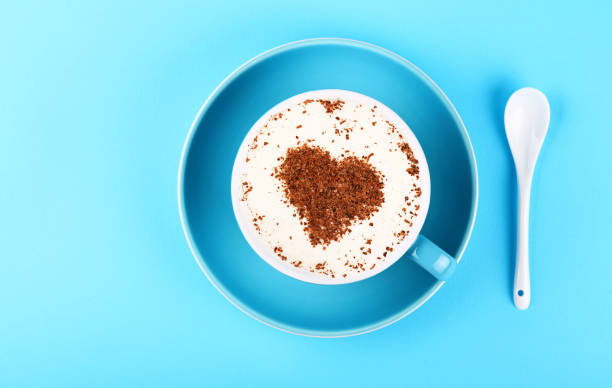 Full cup of latte cappuccino coffee on blue paper