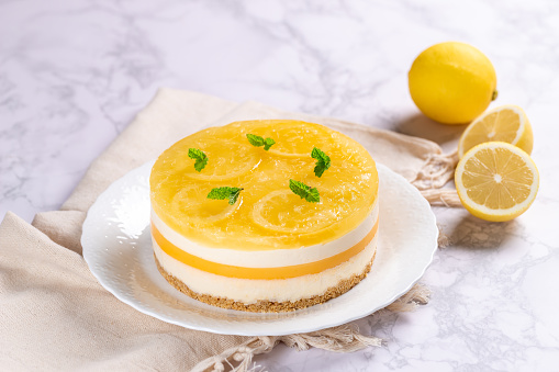 Homemade Layered Lemon Cheesecake isolated on marble background