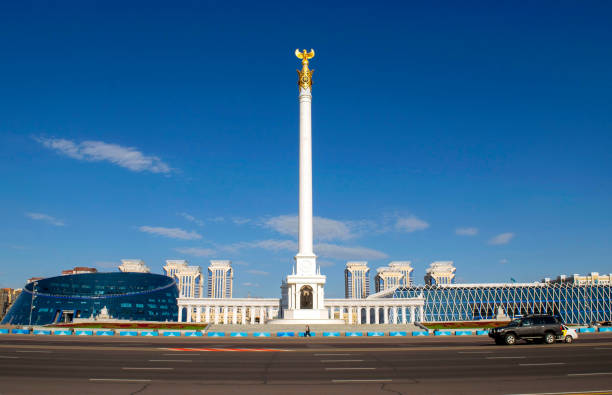 Kazakh Eli Monument with Independence square, Kazakh National University of the Arts, Palace of Independence on Tauelsizdik avenue during a day stock photo