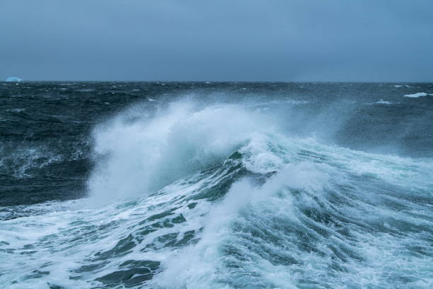 istock A wave breaks on the open seas while high winds blow the spray off the crest 1326096566