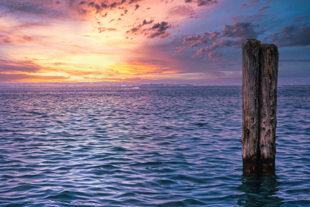 причальные столбы в озере гарда. - lake garda sunset blue nautical vessel стоковые фото и изображения