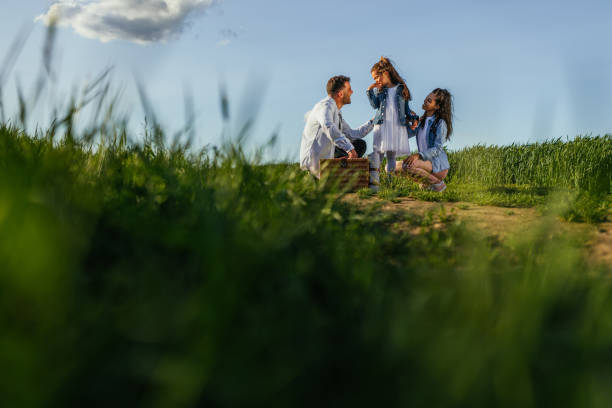 Cute child and her parents hiking the nature together, enjoying the day outdoors.