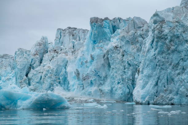 istock Series showing large chunks of ice calving from a craggy glacier, causing a large splash 1326099234