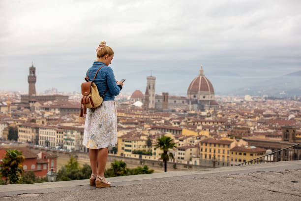 istock Woman With Backpack In Florence City Using Cellphone 1326099306
