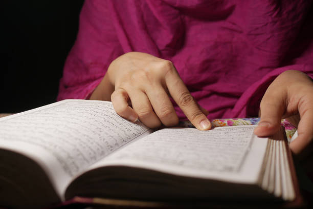 istock Muslim women's hand reading quran at night 1326099458