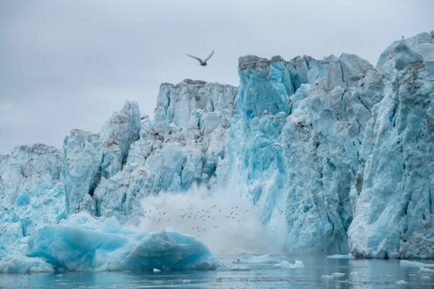 istock Series showing large chunks of ice calving from a craggy glacier, causing a large splash 1326100234