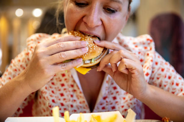 istock Young Woman Eating Burger 1326101959