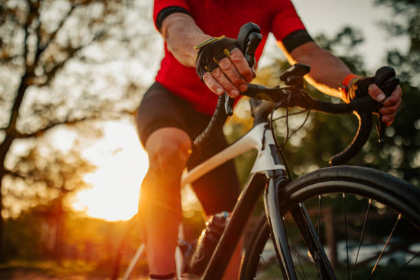 Close up of man riding bike Close up of senior man riding bike through forest cycling stock pictures, royalty-free photos & images