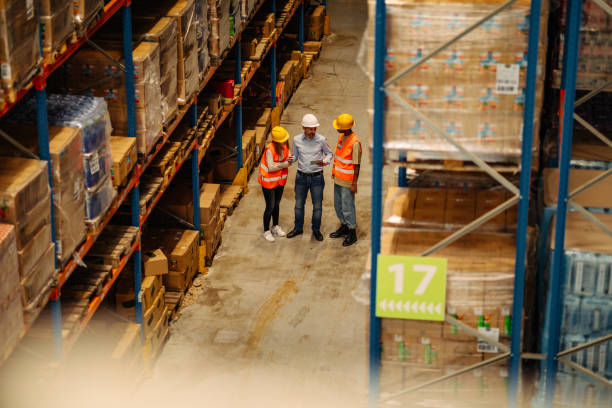 istock Manager with workers controlling stock in factory warehouse 1326106615